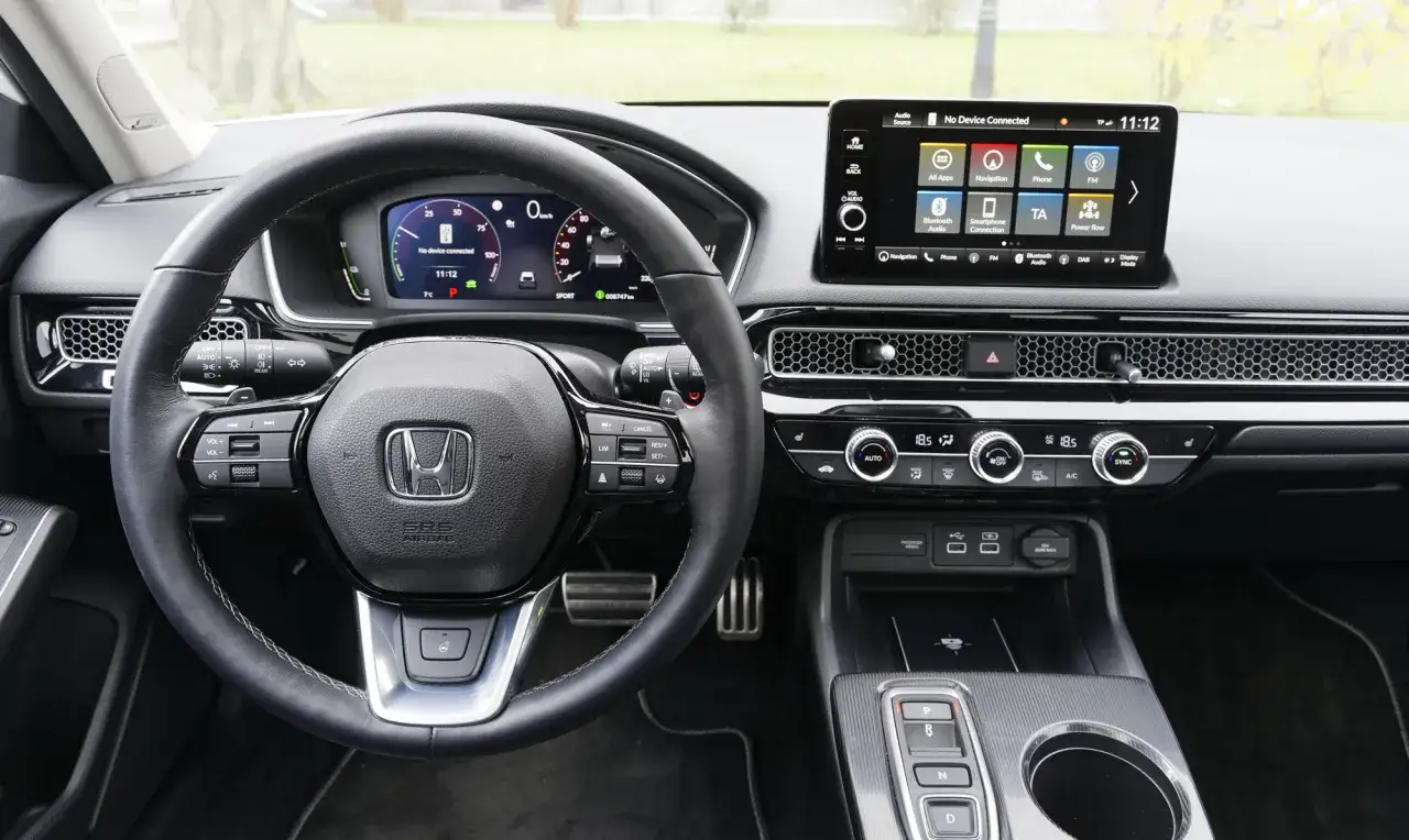 Wnętrze Honda Civic 2025: kierownica, cyfrowe zegary i ekran multimediów.