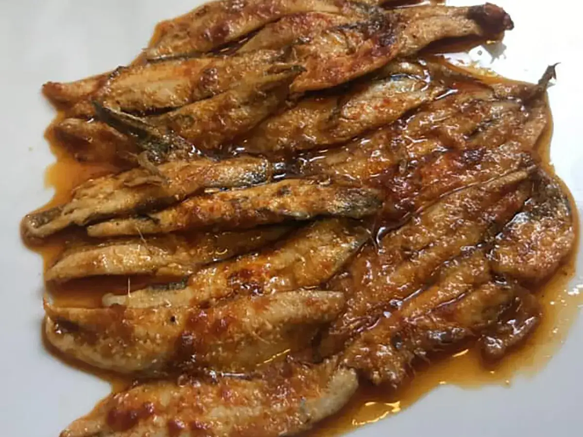 Alici in padella, dorate e succulente, nappate in un sugo ambrato. Un piatto semplice ma gustoso.