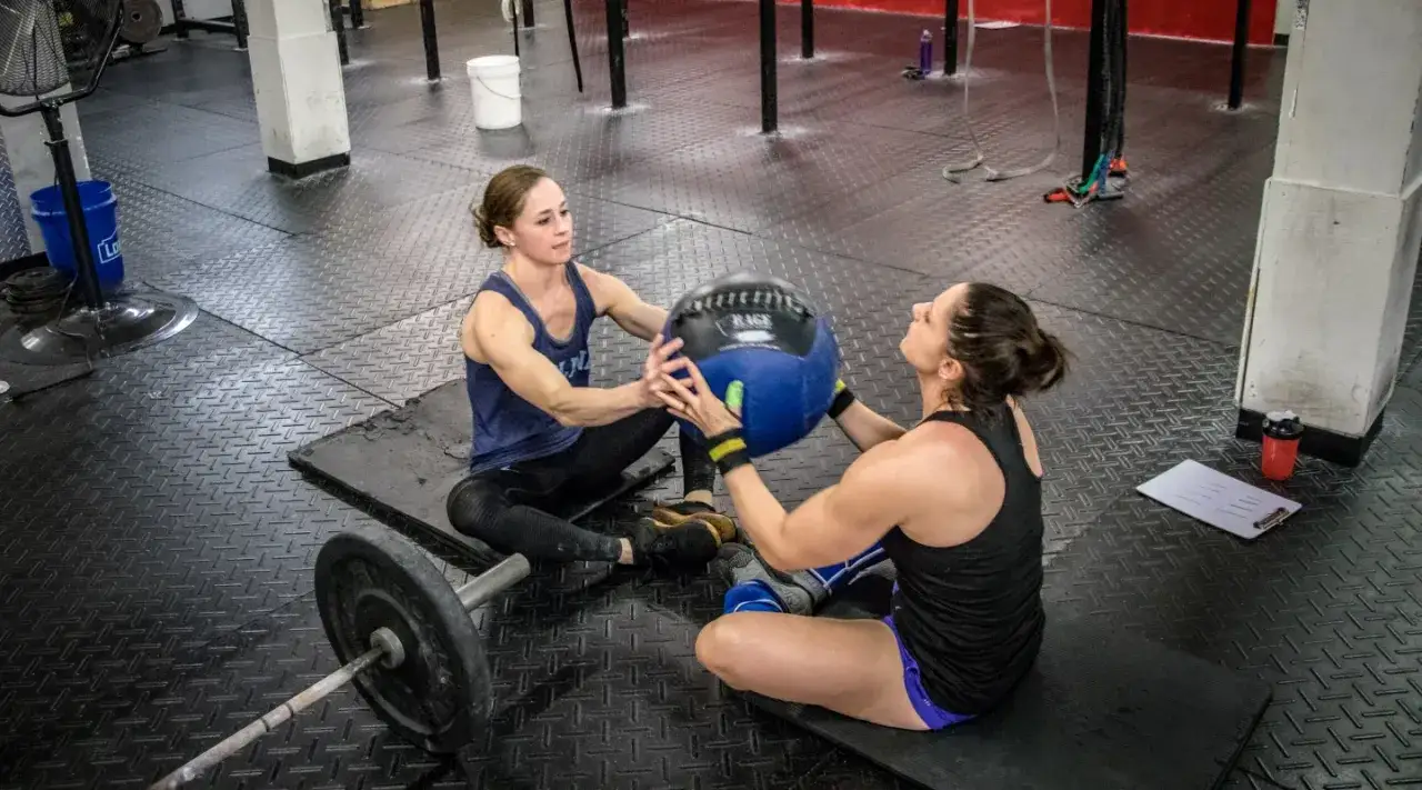 Due donne si allenano con una palla medica in palestra, pronte per il next club Torino.