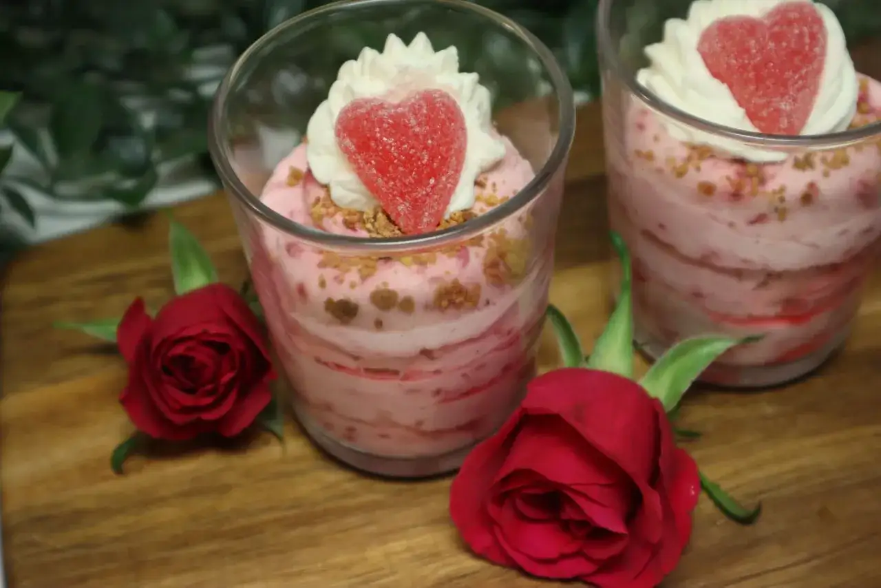 En härlig dessert med rosa lager, toppad med grädde och ett hjärta. Perfekt för ett vit choklad recept.