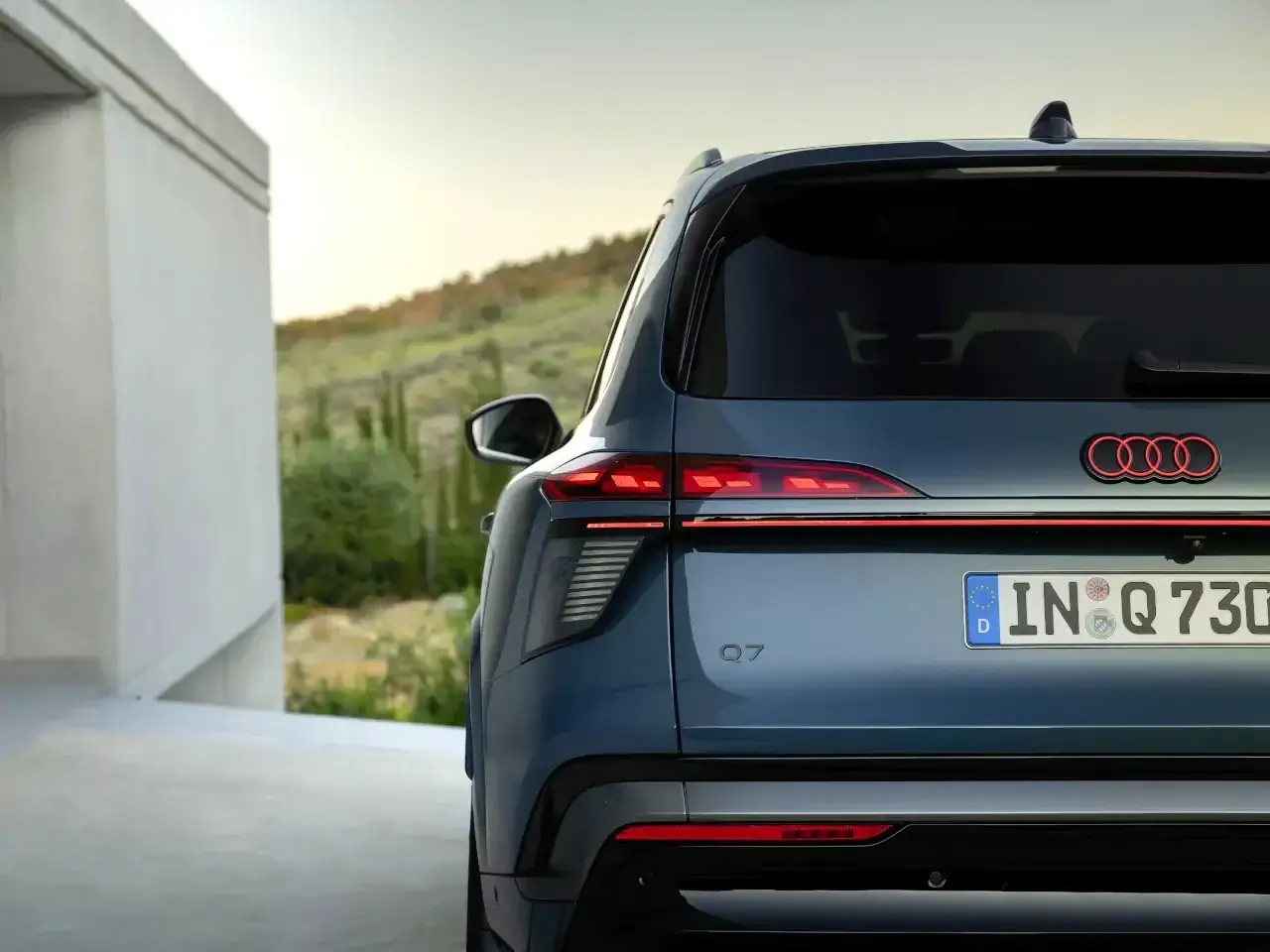 Nowe Audi Q7 w kolorze morskim, z charakterystycznymi światłami LED i logo Audi.