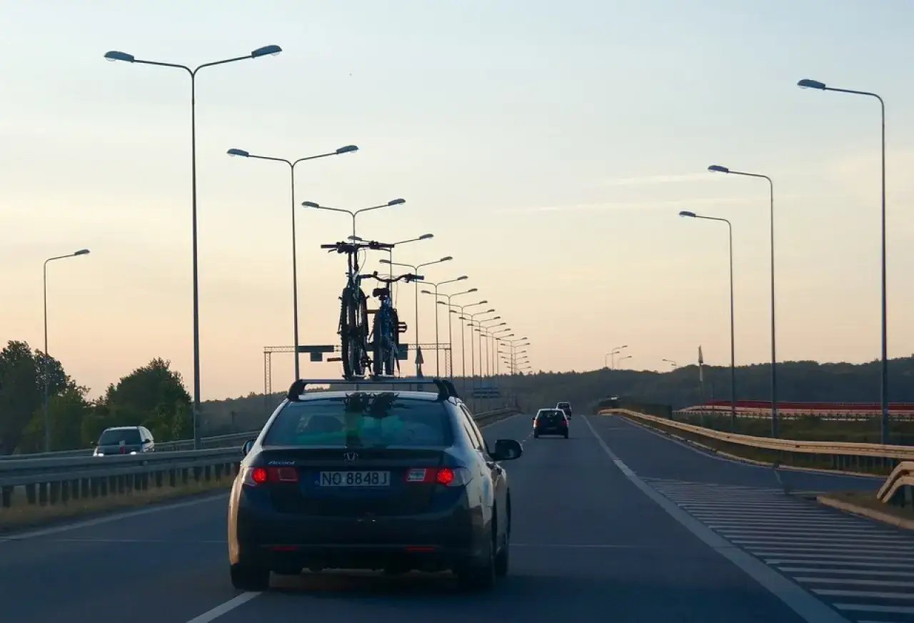 Samochód z rowerami na dachu jedzie autostradą, szukając drogi jak dostać się do morza.