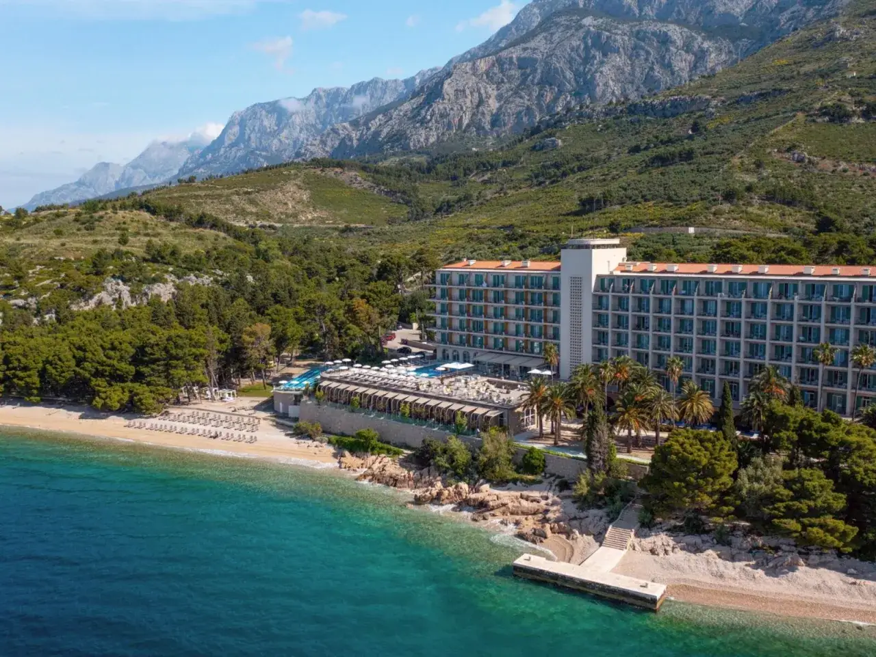 Traumhafter Blick auf das TUI Blue Jadran Hotel an der kroatischen K&uuml;ste, mit t&uuml;rkisfarbenem Meer und Bergen im Hintergrund.