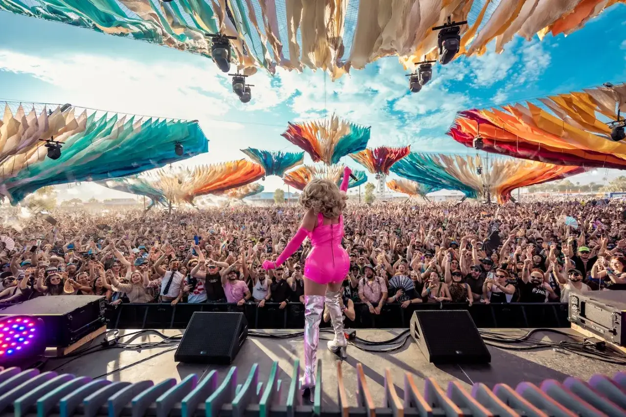 Występ na festiwalu, który trwa kilka dni, jak Coachella. Tłum szaleje, a artystka w różowej kreacji króluje na scenie.