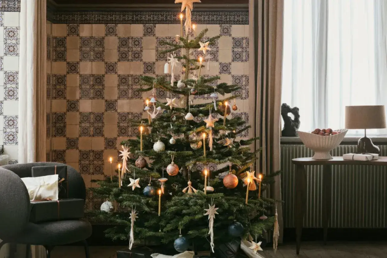 Festlich geschmückter Tannenbaum mit Kerzen und Sternen. Die Frage