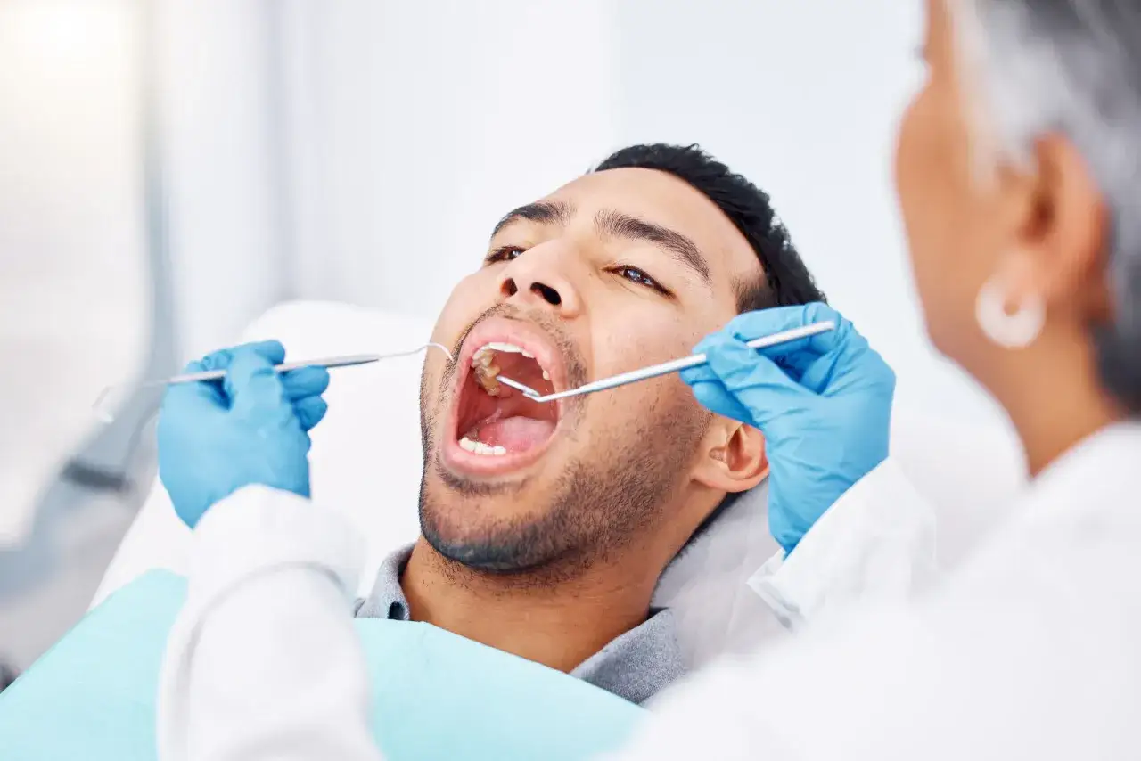 Dentysta bada zęby pacjenta, który chce dowiedzieć się, jak wybielić zęby.