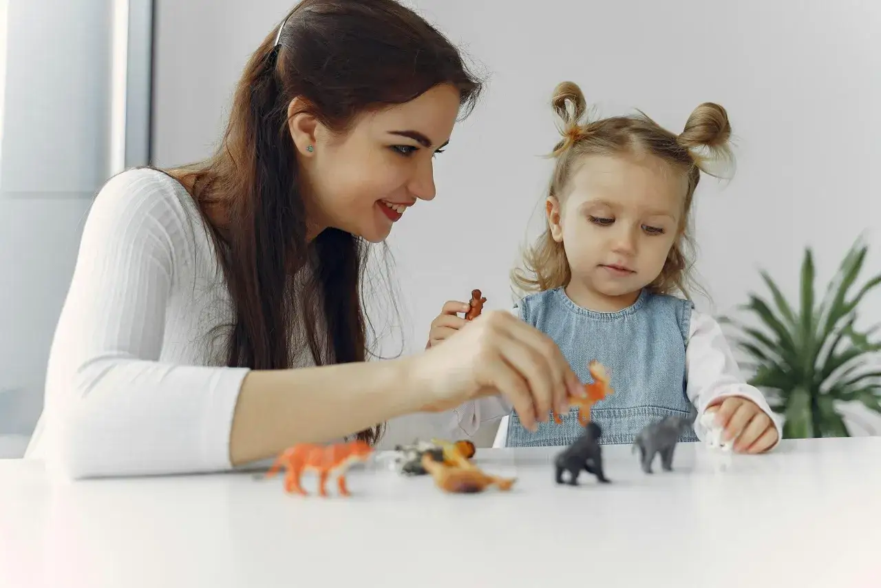 Mama i córka bawią się figurkami zwierząt. Dzień pupila w domu, pełen radości i wspólnej zabawy.
