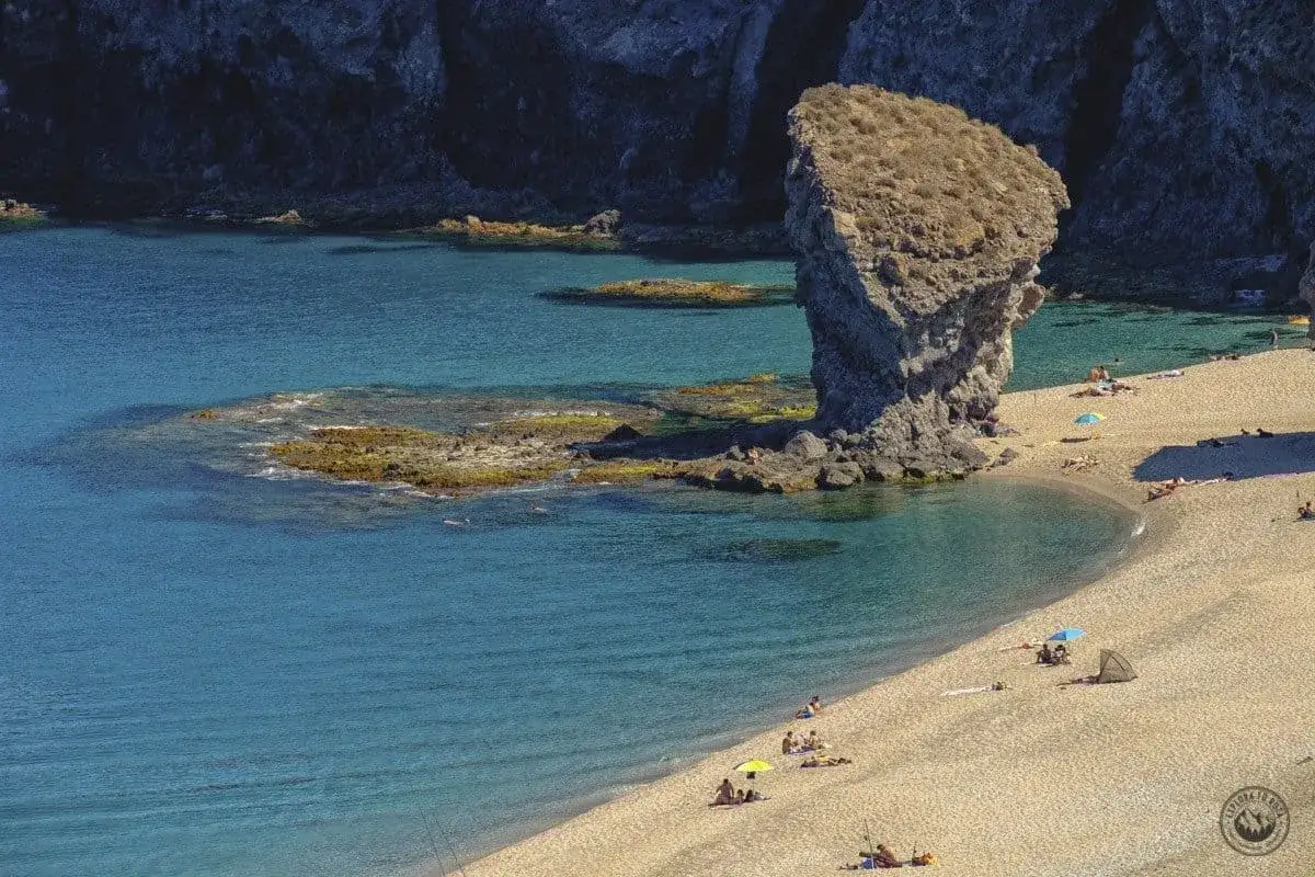 Playa de los Muertos, un lugar idílico para saber qué hacer en Carboneras. Arena dorada, aguas cristalinas y un peñón imponente.