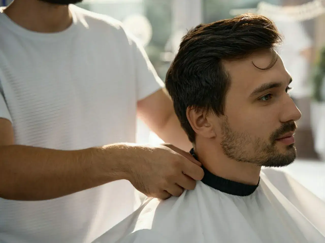 Stylista pomaga mężczyźnie z rzadkim zarostem, jak zapuścić brodę.