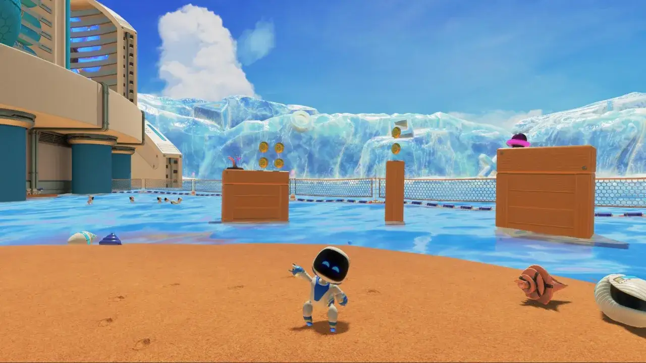 Astro z Astro's Playroom skacze na plaży, zbierając monety. W tle lodowe góry i basen.
