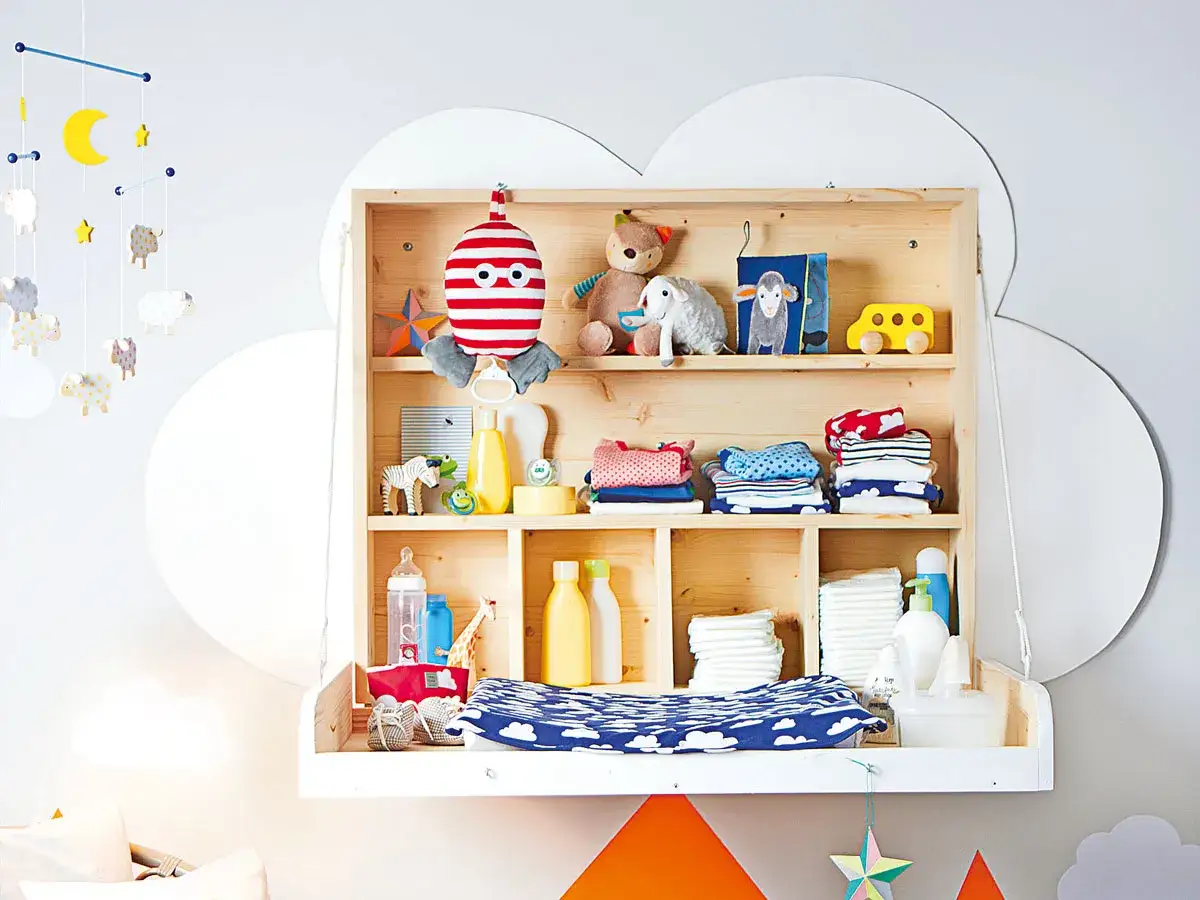Selbstgemachte Wickelkommode mit Spielzeug, Kleidung und Pflegeprodukten für Babys.