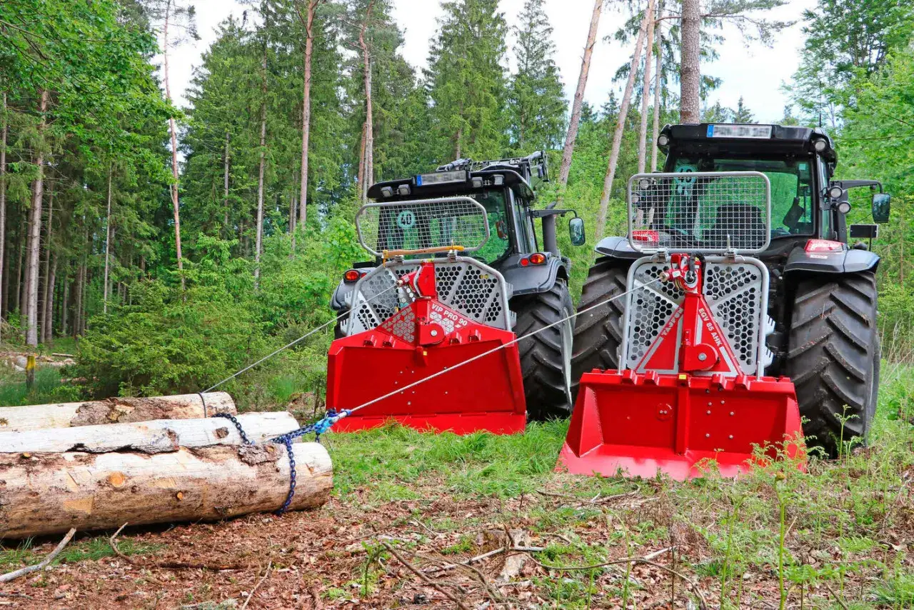 Zwei Traktoren mit seilwinde forst im Wald, bereit, Holz zu ziehen.