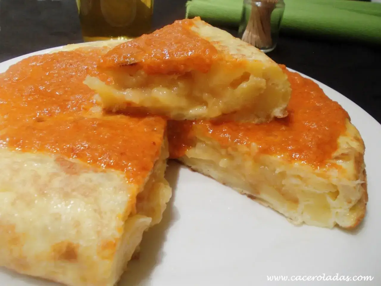 Tortilla española con salsa de pimientos, un clásico de las recetas con patatas.