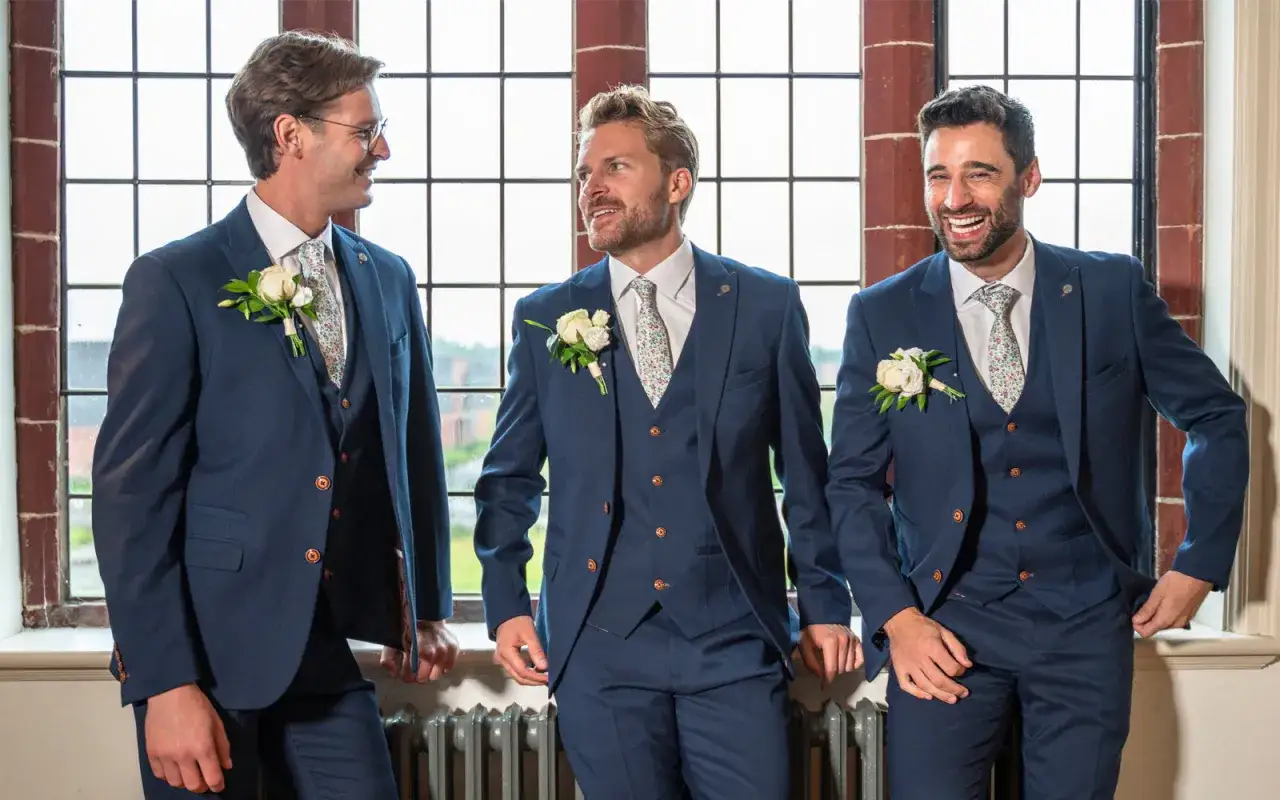 Three groomsmen in navy suits with floral ties and boutonnieres, ready for the usher wedding.