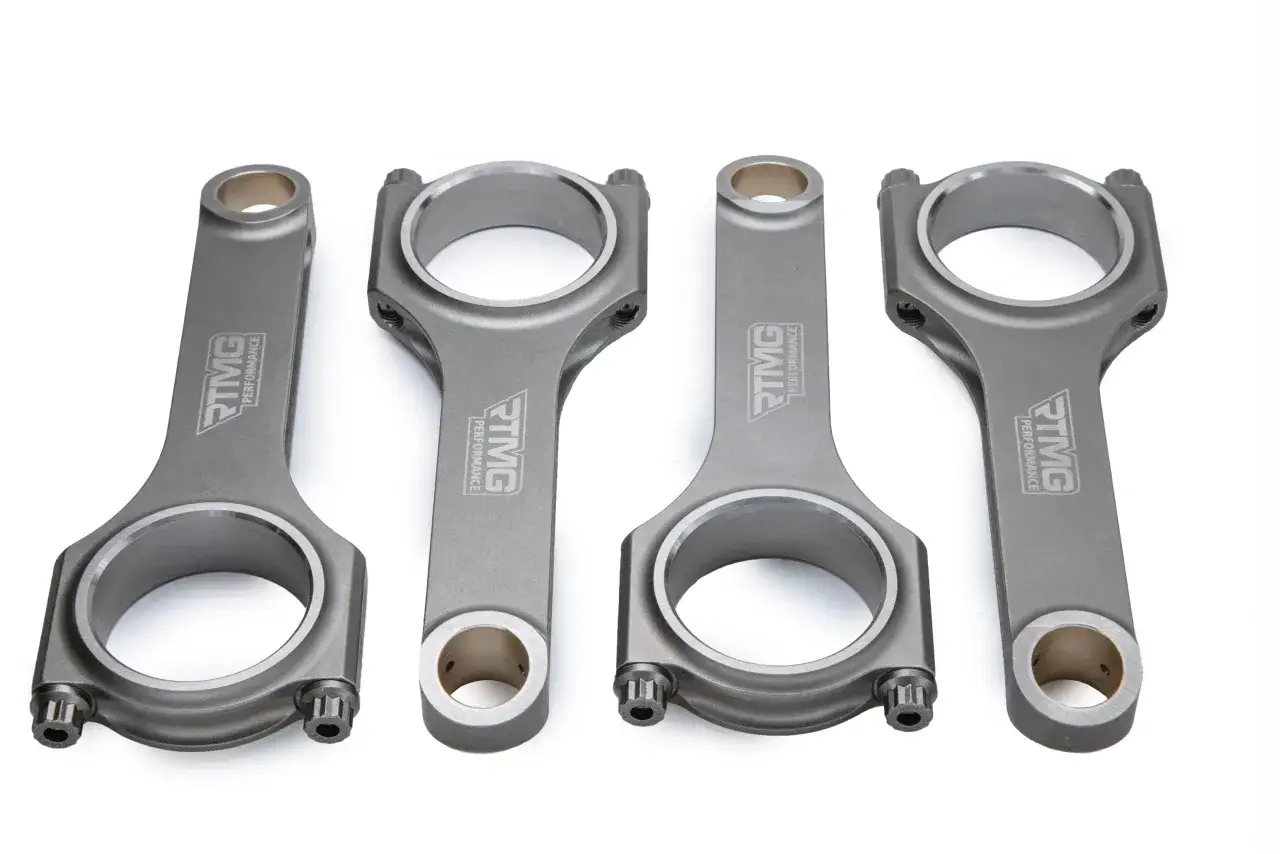 Quattro bielle in metallo, un pezzo meccanico essenziale per motori ad alte prestazioni, con logo TMG Performance inciso.