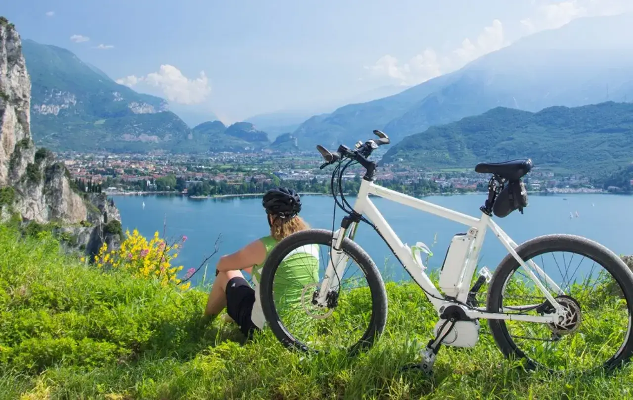 Ciclista ammira il panorama sul lago, con la sua e-bike pronta per altre passeggiate a San Felice del Benaco.