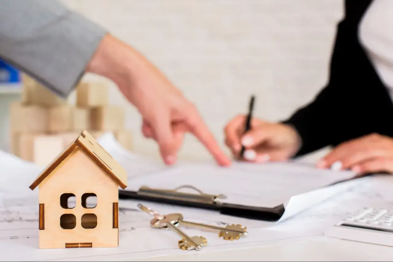 Maquette de maison, clés et signature d'un contrat. Une étape clé pour une vente à réméré réussie.