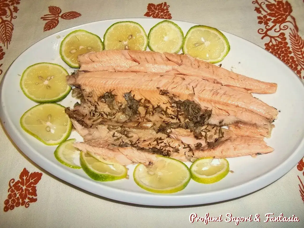 Trota salmonata al forno, profumata alle erbe e guarnita con fette di limone. Un piatto leggero e saporito.
