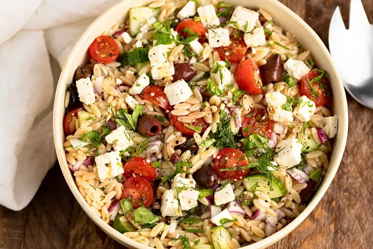 Ein köstlicher griechischer Orzo Salat mit Tomaten, Gurken, Oliven und Feta. Frisch und leicht, perfekt für den Sommer.