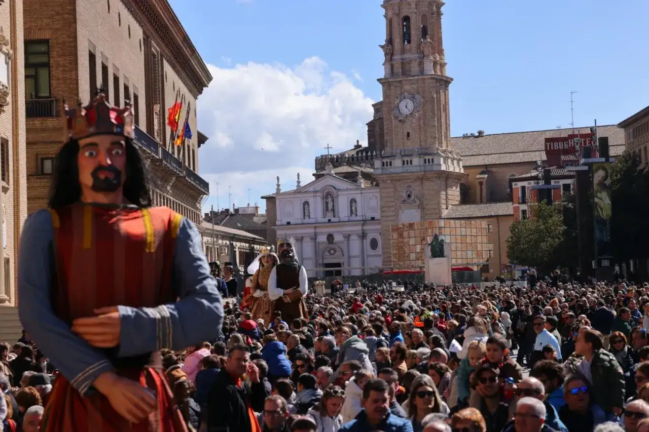 Gigantes y cabezudos en las fiestas del Parque Goya, Zaragoza. Una multitud celebra en la plaza ante la Basílica del Pilar.