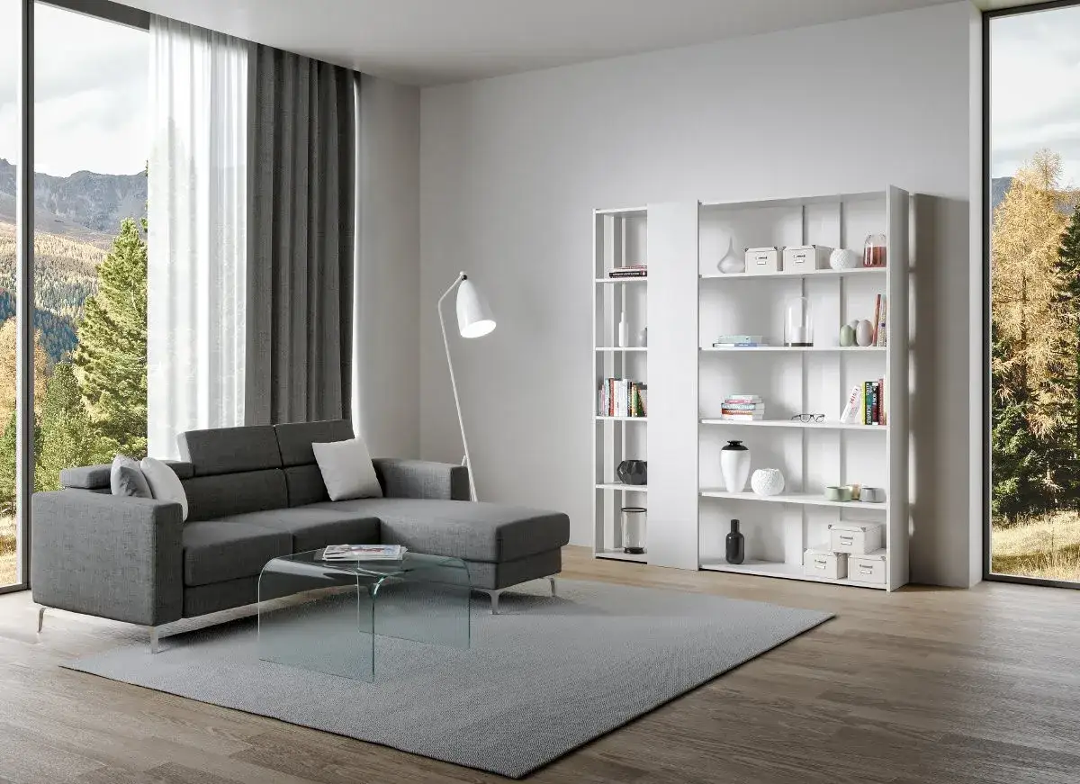Soggiorno moderno con divano grigio, tavolino in vetro e due **piccole librerie** bianche piene di libri e oggetti decorativi.