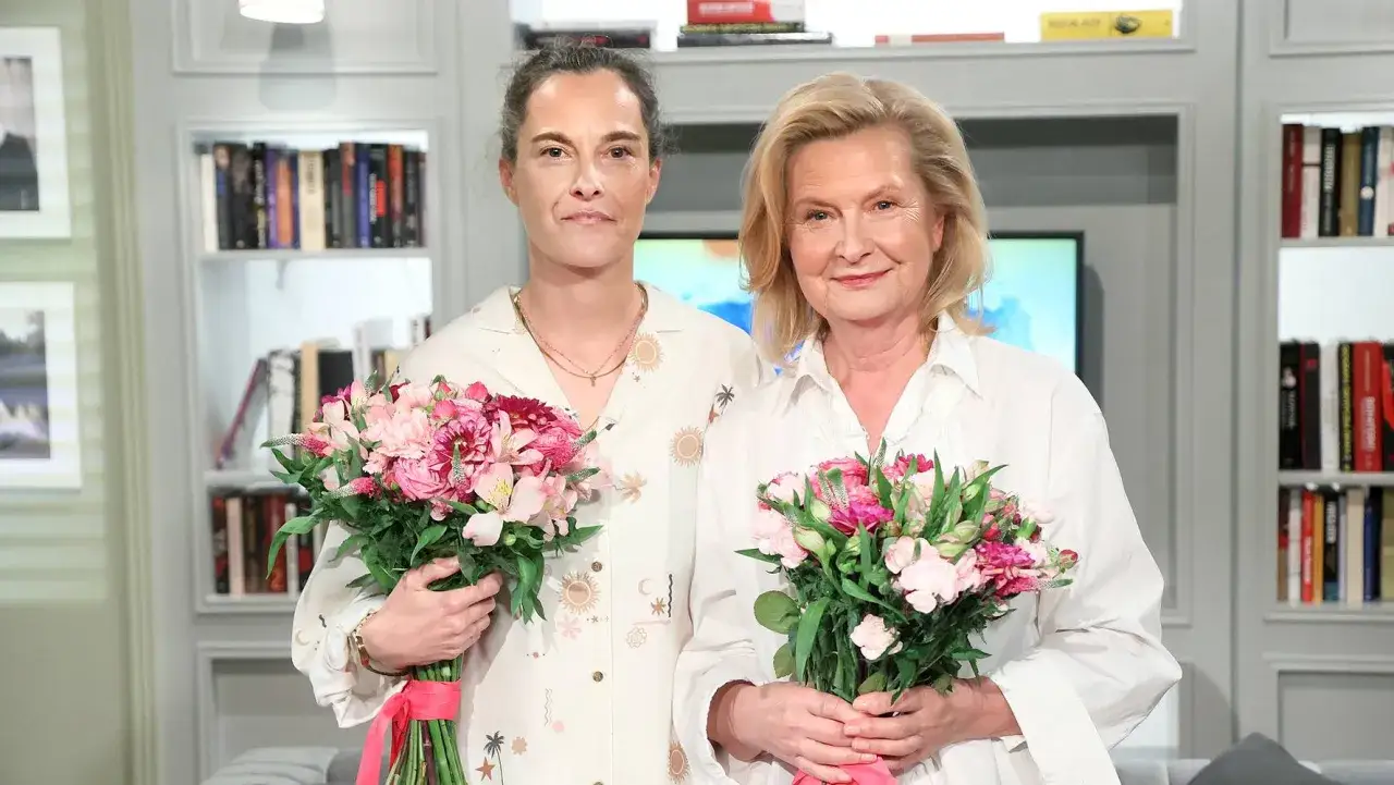 Barbara Bursztynowicz z córką, obie trzymają bukiety różowych kwiatów.