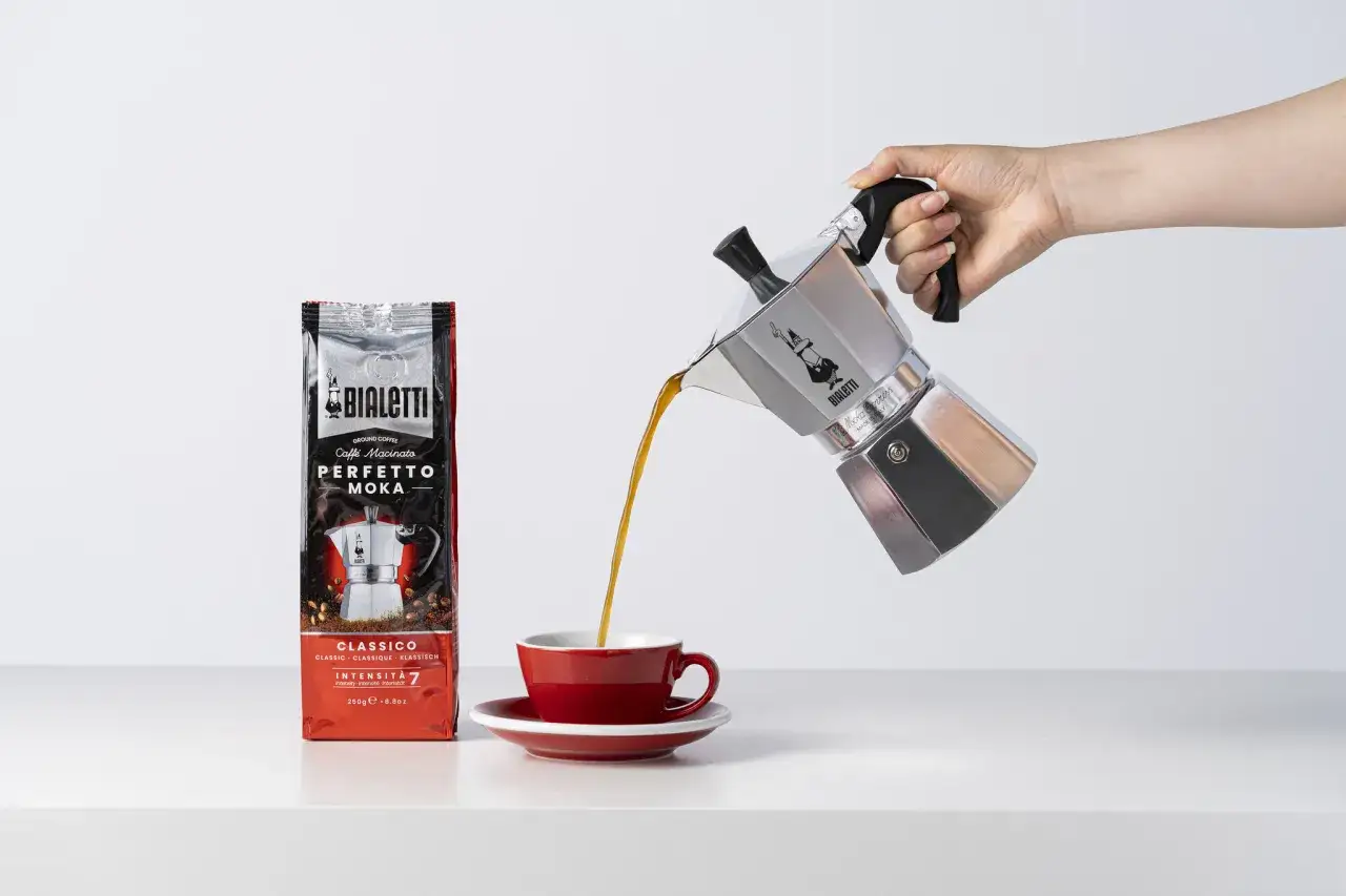 Aromatyczna kawa Bialetti Perfetto Moka Classico nalewa się z kawiarki do czerwonej filiżanki. Jaka kawa pobudzi Cię dziś?
