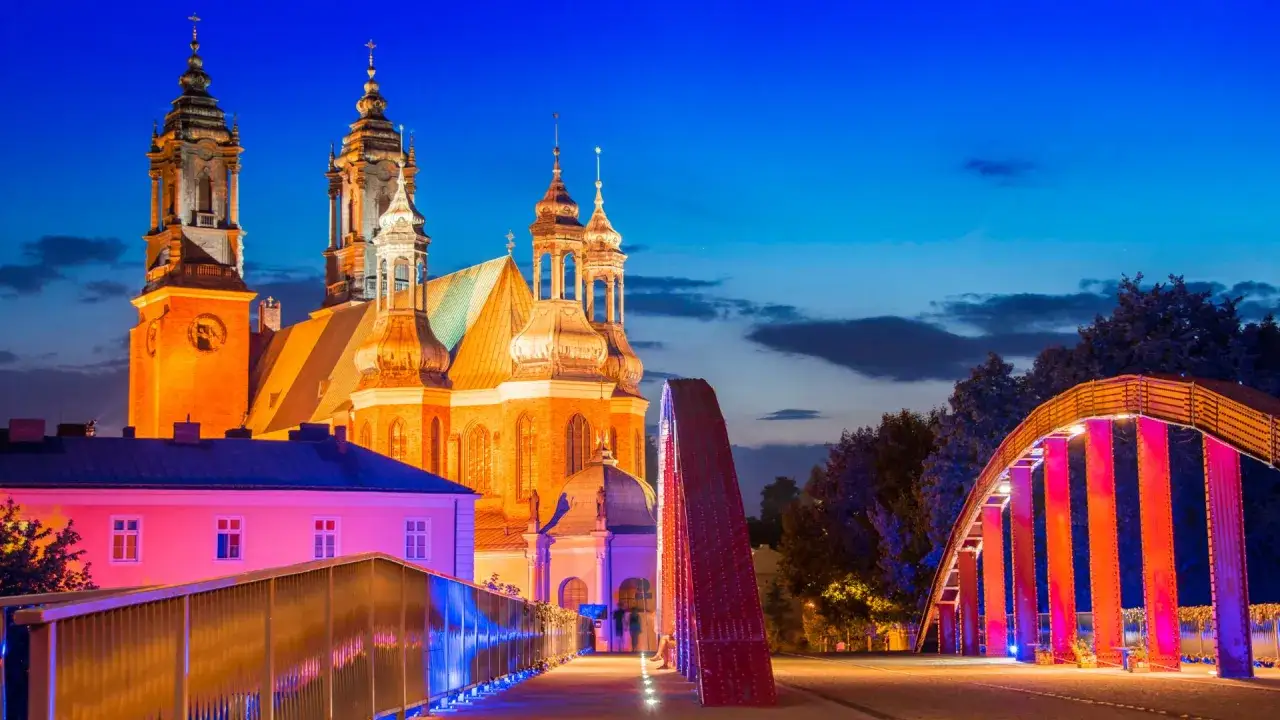 Wieczorny Poznań: iluminowana katedra i nowoczesne mosty, idealne poznańskie atrakcje dla dorosłych.