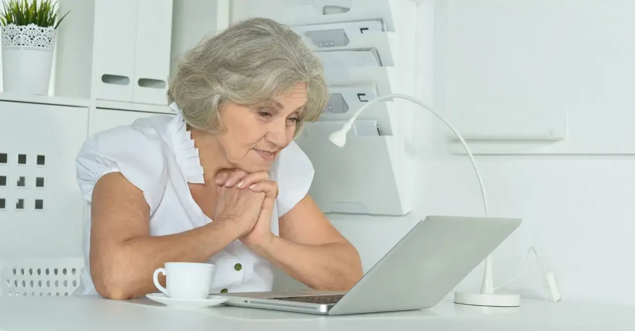 Dojrzała kobieta korzysta z laptopa, szukając informacji o stażu z urzędu pracy powyżej 30 roku życia i programach dla osób w dojrzałym wieku.