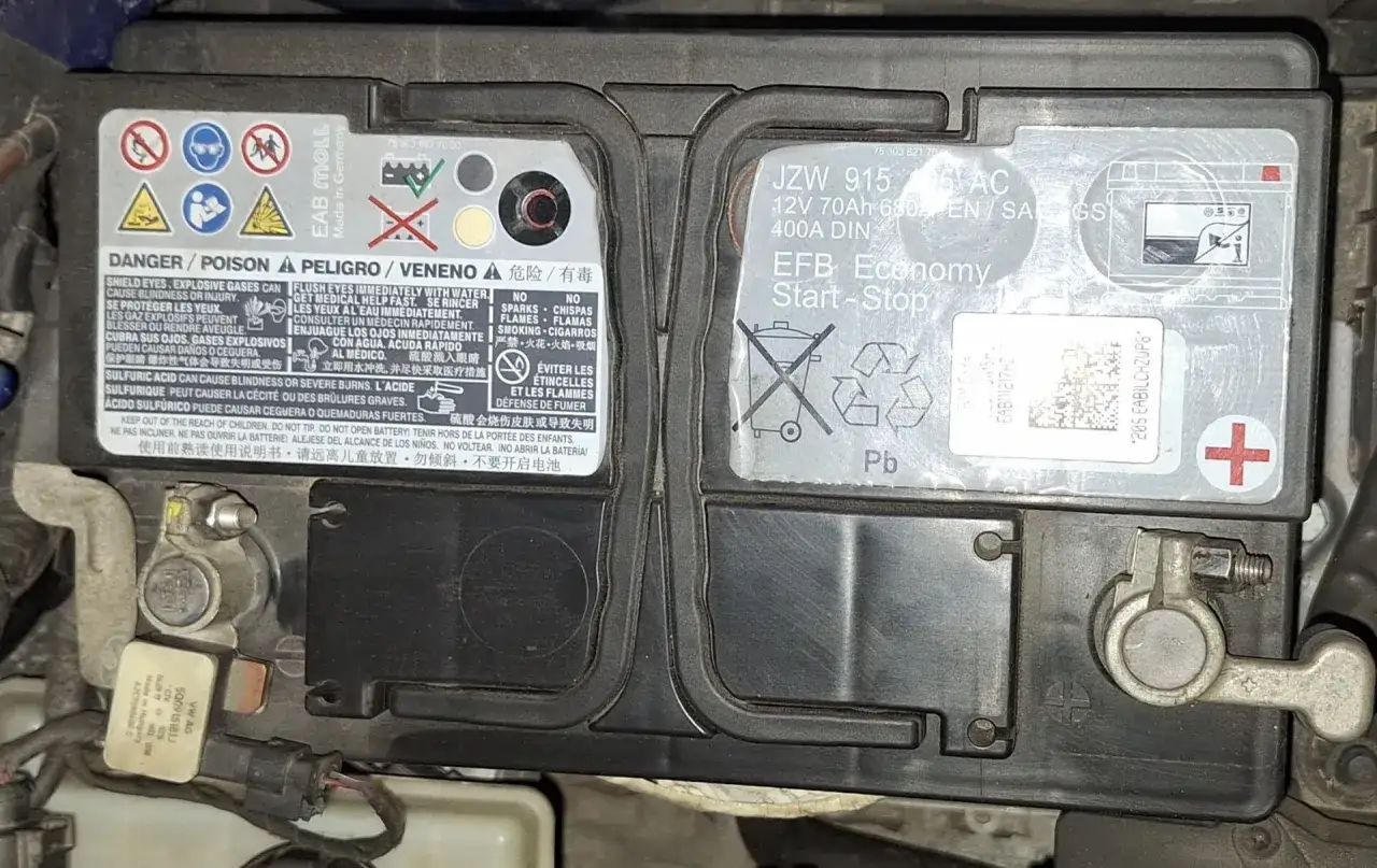 Akumulator Skoda Octavia EFB 70Ah 400A DIN. Widoczne ostrzeżenia o zagrożeniach i symbole recyklingu.