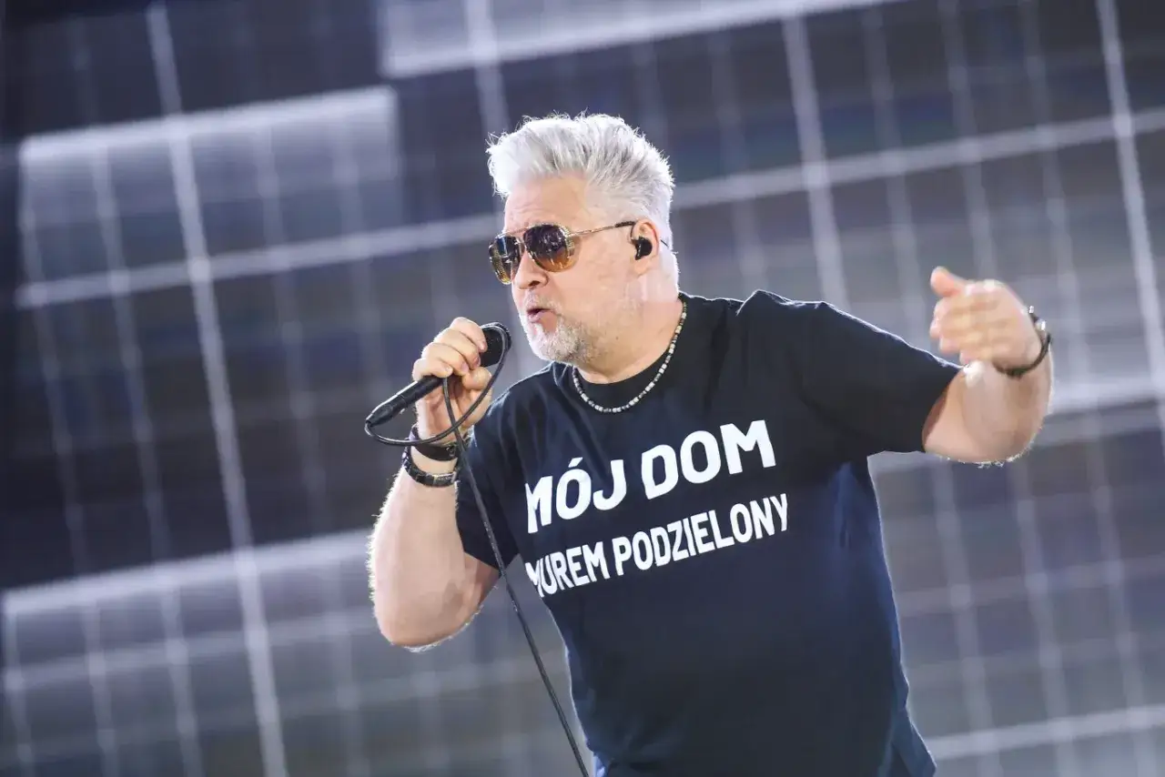 Artur Gadowski z IRA śpiewa na koncercie w czarnej koszulce z napisem 