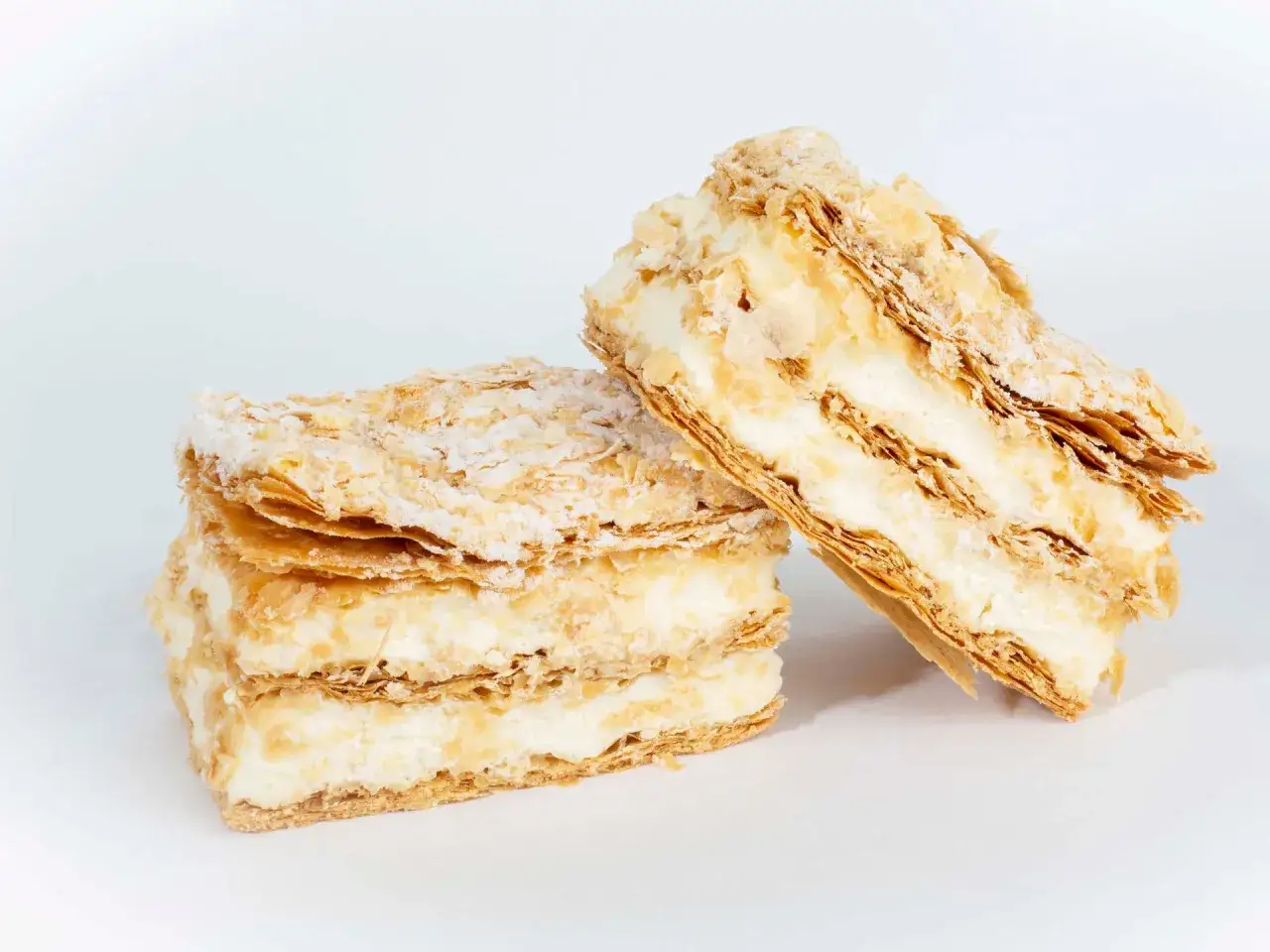 Dos porciones de costrada de Soria, un postre hojaldrado con crema, espolvoreadas con az&uacute;car glas.