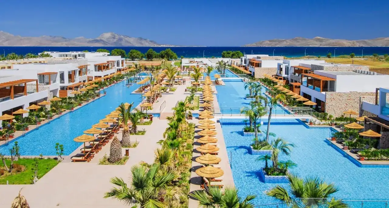 Luksusowy resort z basenami i palmami nad morzem, idealne miejsce na wakacje na Caravia Beach Kos.