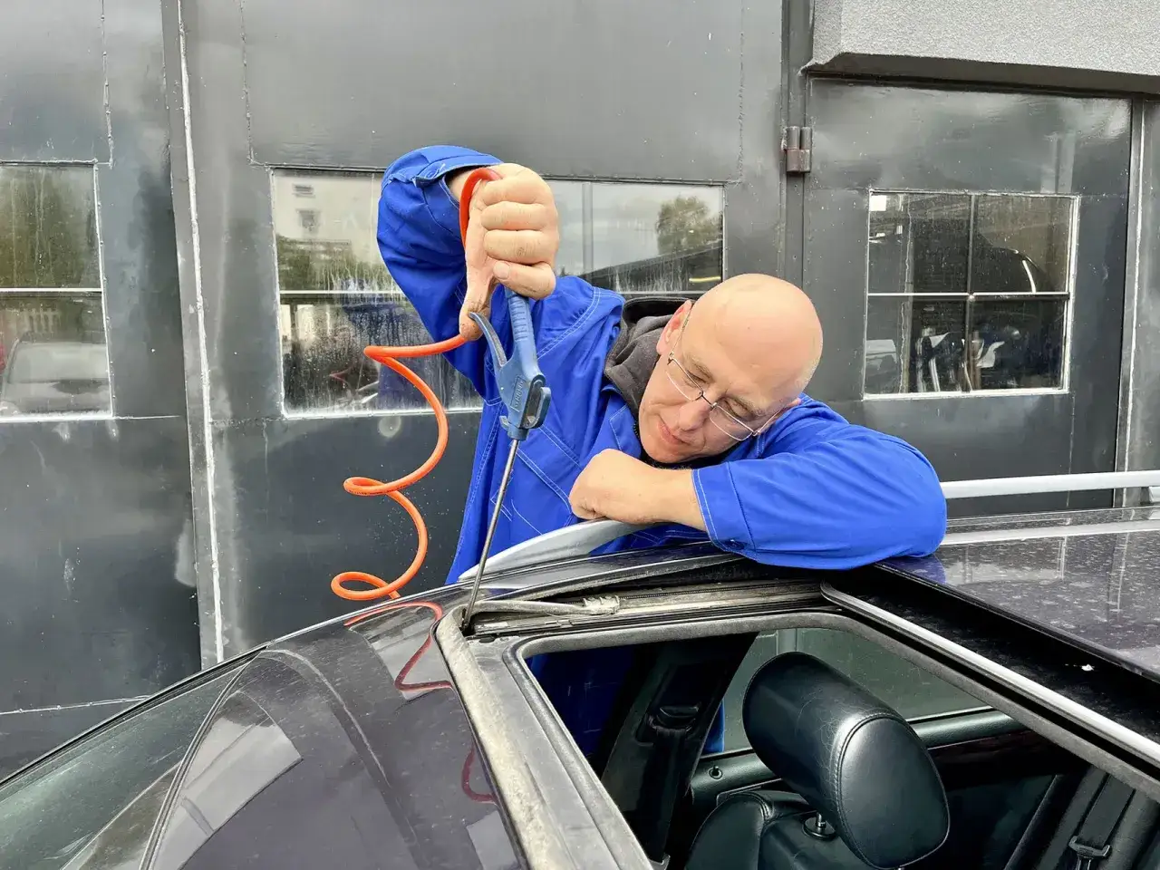 Mechanik przedmuchał sprężonym powietrzem dach auta, by usunąć kurz. Teraz podłoga w aucie jest sucha.
