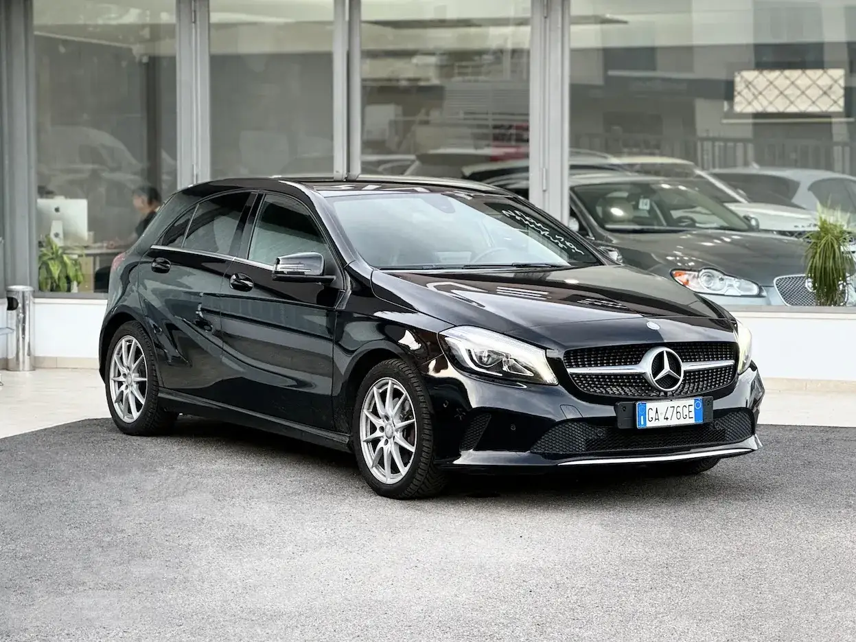 Elegante Mercedes Classe A 180 CDI nera, parcheggiata davanti a un concessionario.