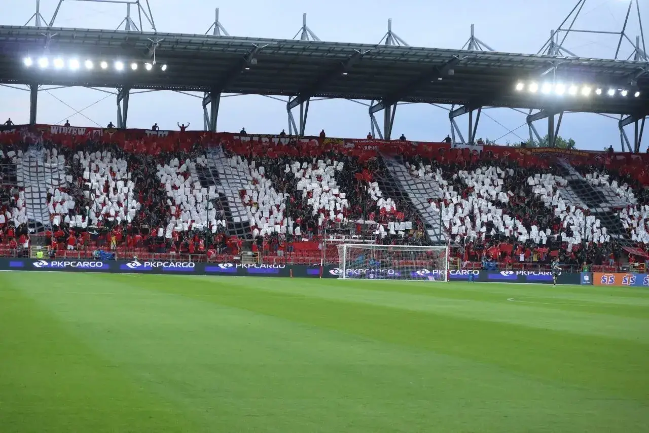 Trybuna kibiców Widzewa Łódź tworzy biało-czerwoną mozaikę z herbem klubu. Mecz z Jagiellonią Białystok.