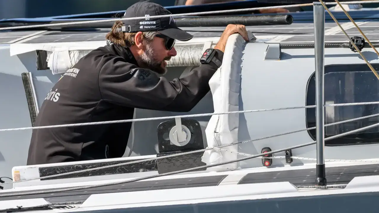 Boris Herrmann, fokussiert w&auml;hrend eines Ocean Race. Er greift nach einem Seil auf dem Boot.
