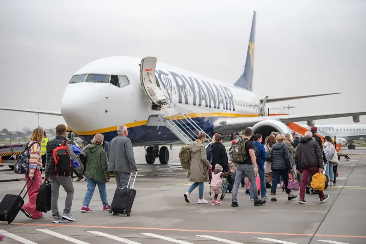 Pasażerowie wsiadają do samolotu Ryanair, gotowi na podr&oacute;ż z Łodzi do Alicante.