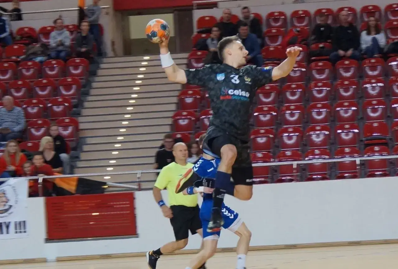 Kacper Grabowski w skoku do rzutu piłką ręczną, próbuje pokonać obronę przeciwnika.