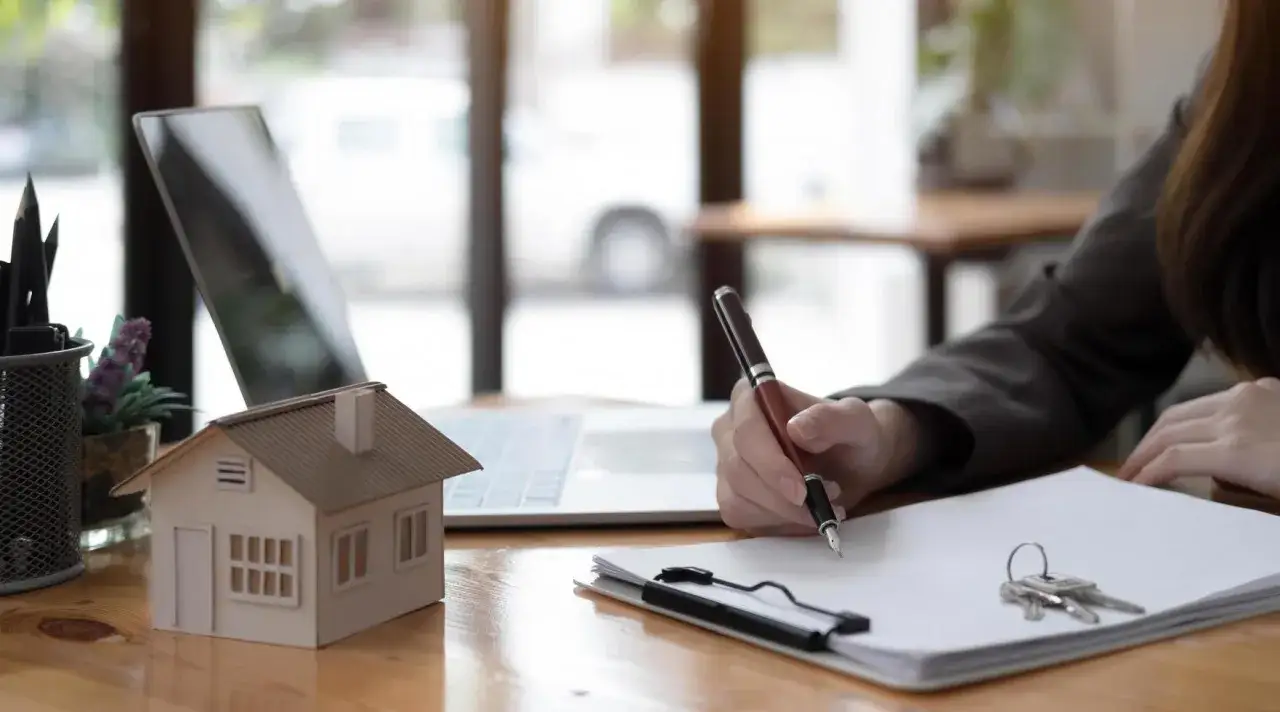 Persona firma contrato de alquiler. Se pregunta cuánto cobra una inmobiliaria por alquilar un piso.