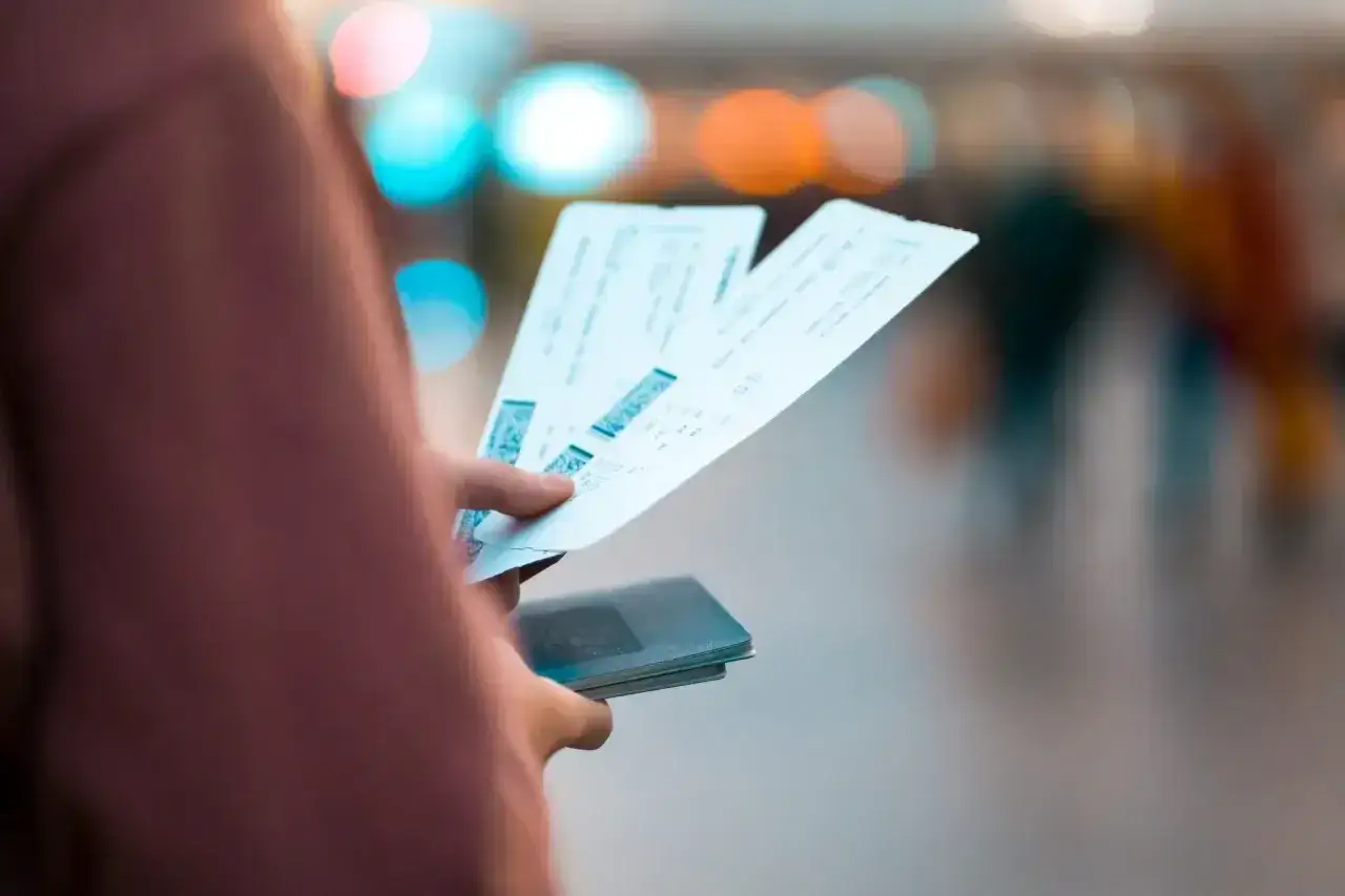 Ręka trzyma bilety lotnicze i paszport. Zastanawiasz się, czy można zwrócić bilety Ryanair?
