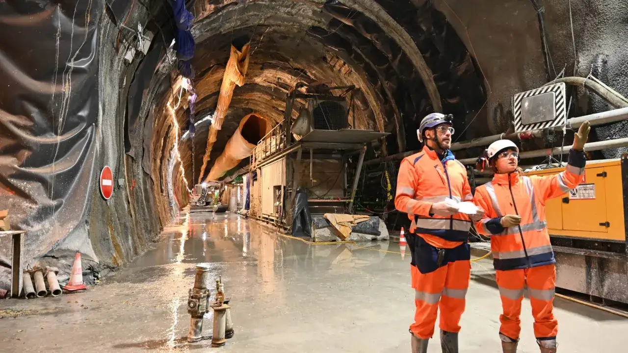 Ingegneri civili in cantiere discutono del progetto, forse valutando quanto guadagna un ingegnere civile per lavori cos&igrave; complessi.