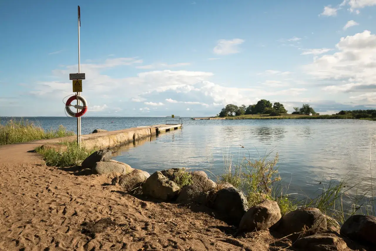 En brygga och en livboj vid vattnet, perfekt f&ouml;r en avkopplande stund under camping i Kalmar.