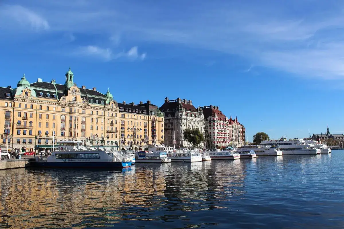 Vackra byggnader längs vattnet i Östermalm, Stockholm, med flera båtar förtöjda.