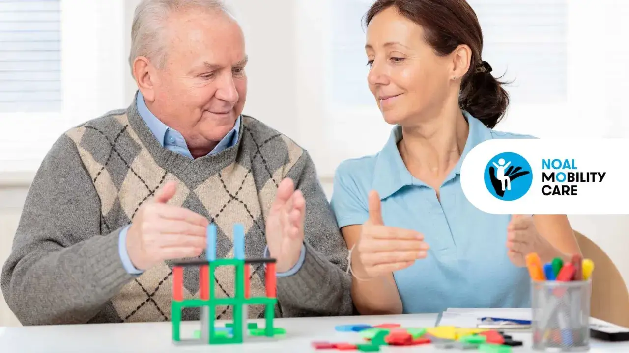Un anziano e una terapista occupazionale interagiscono con blocchi colorati. La terapista occupazionale cosa fa? Aiuta a migliorare le capacità motorie e cognitive.