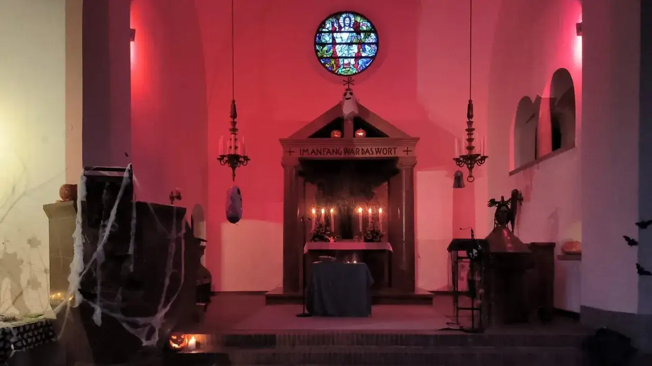 Kirche mit Spinnweben, K&uuml;rbissen und einem Geist-Dekor. Ein Ort f&uuml;r Reformationstag, nicht Halloween.