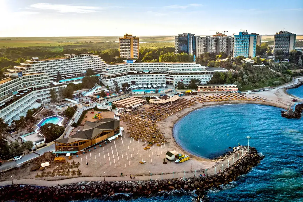 Widok na kurort nad Morzem Czarnym w Rumunii z hotelami, basenami i plażą pełną leżaków.