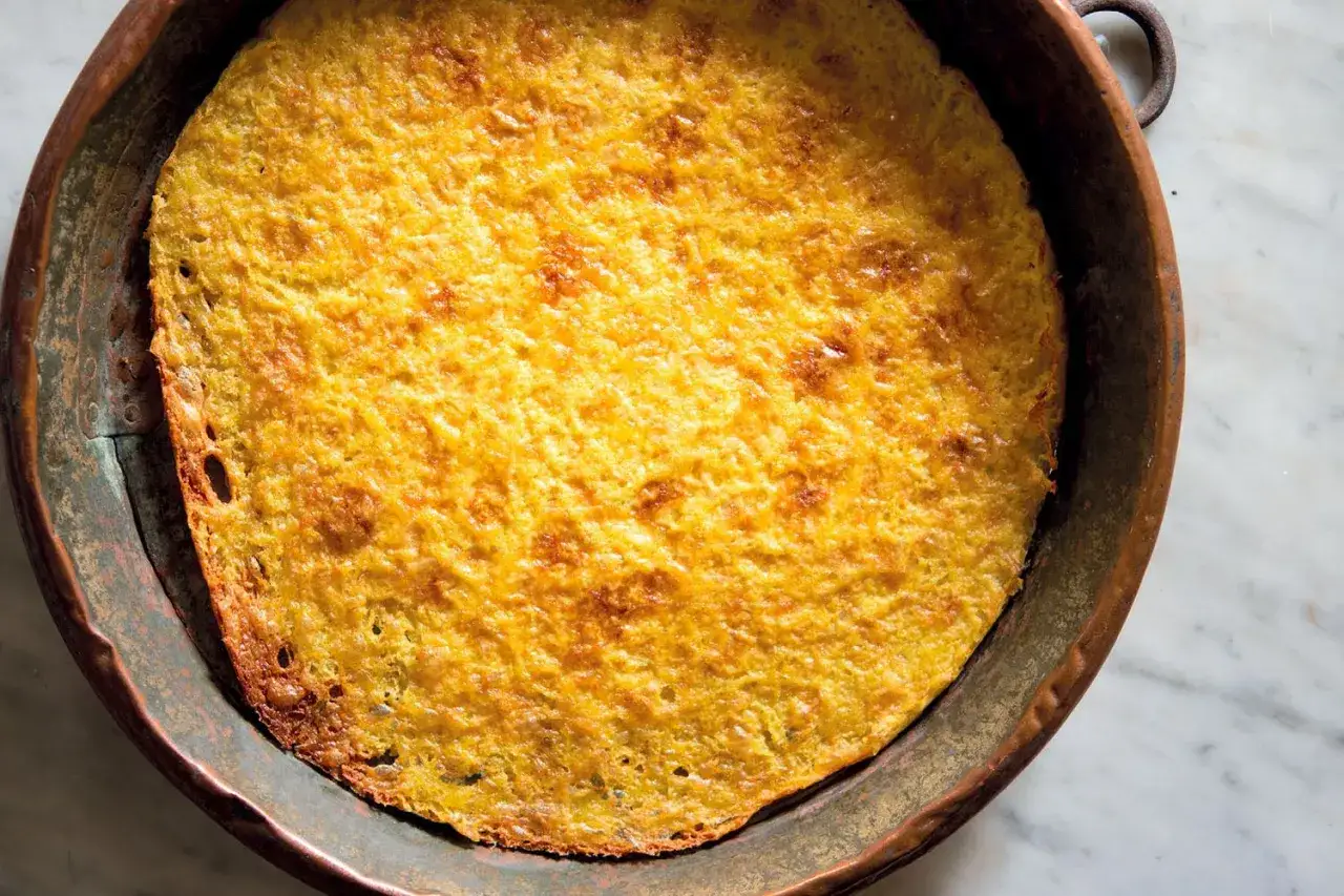Una gustosa torta dorata, perfetta ricetta con farina di ceci, cotta in una padella di rame.