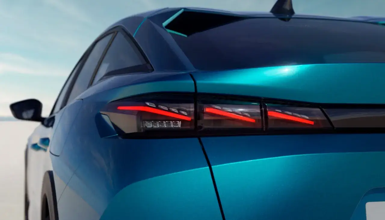 Nowy Peugeot 408 w turkusowym kolorze, z charakterystycznymi tylnymi światłami w kształcie pazurów.
