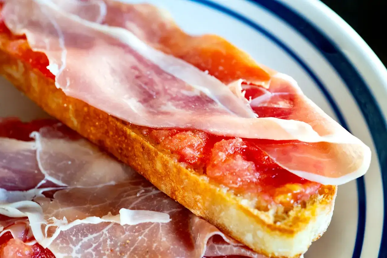 A delicious jamon iberico sandwich on toasted bread with grated tomato.